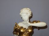 a statue of a woman holding a pipe in her hand