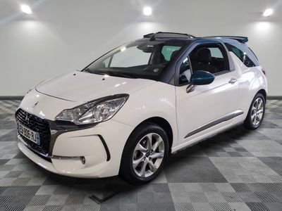 la petite voiture blanche est garée sur un carrelage à carreaux