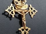 a close up of a cross on a black leather surface