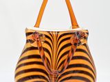 sac à main à motif zébré avec des anses orange sur fond blanc