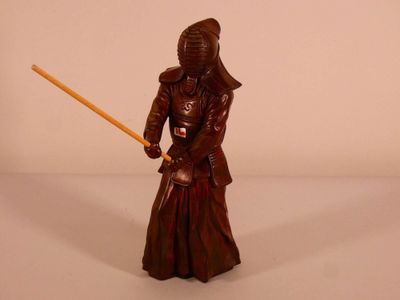 une figurine représentant un homme tenant une épée à la main