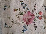 a white purse with a pink flower design on it