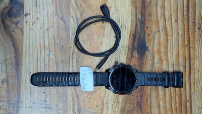 une montre branchée sur un chargeur posé sur une table en bois