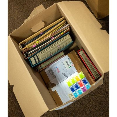 a cardboard box filled with lots of files and post - it notes
