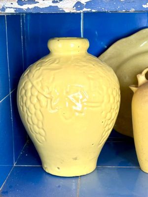 deux vases jaunes posés sur une étagère carrelée de bleu