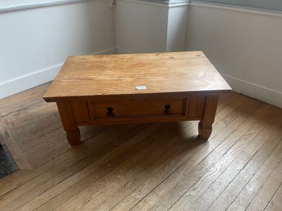 a wooden table with a drawer on it in the corner of a room