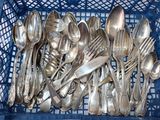 un panier bleu rempli de cuillères en argent et de cuillères