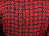 a close up of a woman ' s jacket with a red and black pattern