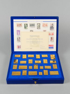 une boîte bleue ouverte contenant une collection de timbres et de timbres