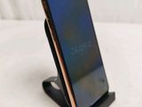 a cell phone that is on a stand on a bed