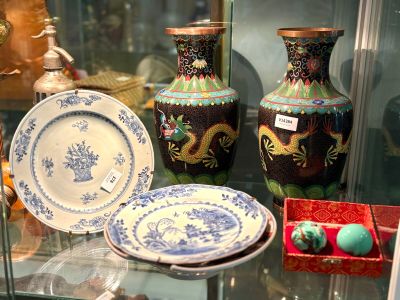Plusieurs vases et assiettes sont exposés dans une vitrine.