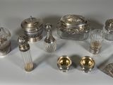 un assortiment d'objets en argent et en verre disposés sur un fond blanc