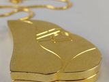 a gold shoe shaped keychain on a white surface