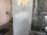 une cloison en verre au milieu d'une pièce, sur laquelle est posé un ordinateur