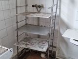 une photo d'une salle de bains avec des toilettes et une étagère