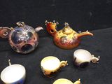 a lot of teapots and cups on the table