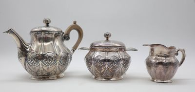 three silverplated teapots and a creamer on a white surface