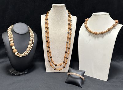 three different necklaces and bracelets on display on a black background