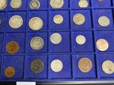 a lot of coins in a display case on a table