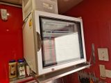 une photo d'un micro-ondes posé sur une étagère dans une cuisine