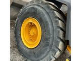 a close up of a tractor tire with a yellow wheel