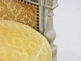 yellow upholstered chair with studded arms and legs