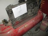 a red air compressor with a sign on top of it