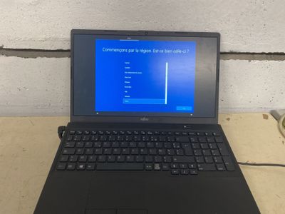 un ordinateur portable posé sur une table avec un écran bleu