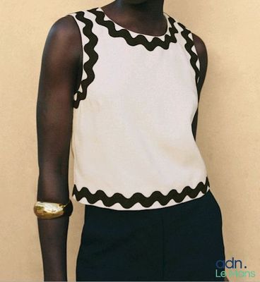 une femme qui pose pour une photo devant un mur