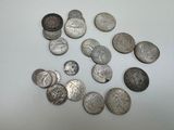 a lot of silver coins on a white surface