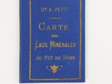 un vieux livre bleu avec des inscriptions dorées sur une page blanche