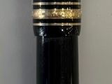 un stylo noir et doré muni d'un manche