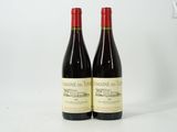 deux bouteilles de vin rouge posées l'une à côté de l'autre sur une surface blanche