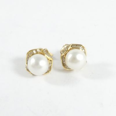 une paire de boucles d'oreilles en perles et diamants sur fond blanc