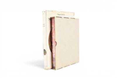 un vieux livre à la couverture rose posé sur une surface blanche