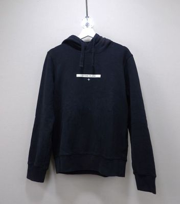 a black hoodie hanging on a hanger against a white wall