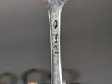 a fork that is sitting in front of a group of silver spoons