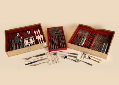 two wooden boxes with silverware in them on a white surface