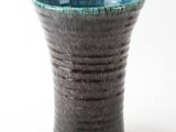 a close up of a vase on a white surface