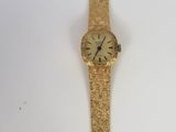 an image of a gold wrist watch on a white surface