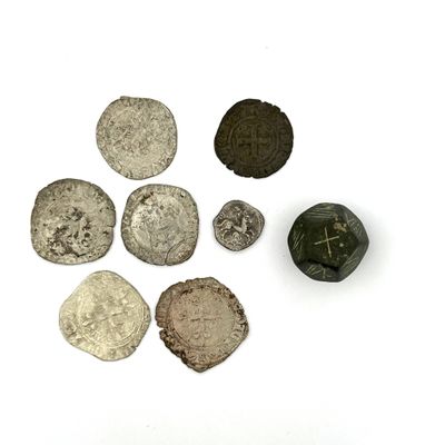 Plusieurs pièces d'argent et de bronze sont disposées sur une surface blanche