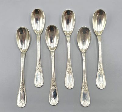 six silver spoons with ornate designs on them sitting on a table