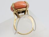 an image of a gold ring with a coral stone in it