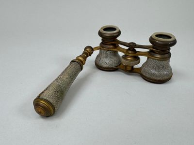 pair of antique brass binoculars on a white background
