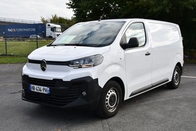 la photo d'une camionnette blanche garée sur un parking