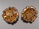 pair of gold tone earrings with green and white stones on them