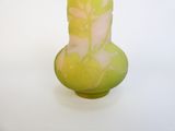 un vase vert orné d'un motif rose et blanc