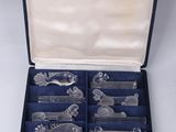 a box with a set of silverware in it on a white surface