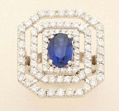 a close up of a blue sapphire and diamond ring on a white background
