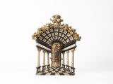 une petite statue représentant un bâtiment avec des colonnes et une horloge au sommet